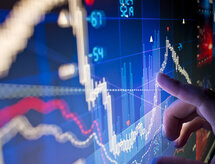 A city worker Analysing stock market data on a monitor.