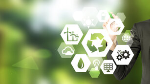 hand drawing signs of different green sources of energy in hexahedron shape, a 'reduce, reuse, recycle' sign in the centre. Blurred green background. Concept of clean environment.