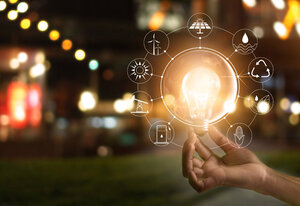 Hand holding light bulb in front of global show the world's consumption with icons energy sources for renewable, sustainable development. Ecology concept. Elements of this image furnished by NASA. 