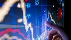 A city worker Analysing stock market data on a monitor.